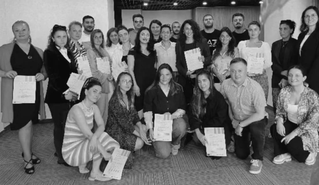 Participants holding their certificates at the end of a training programme.